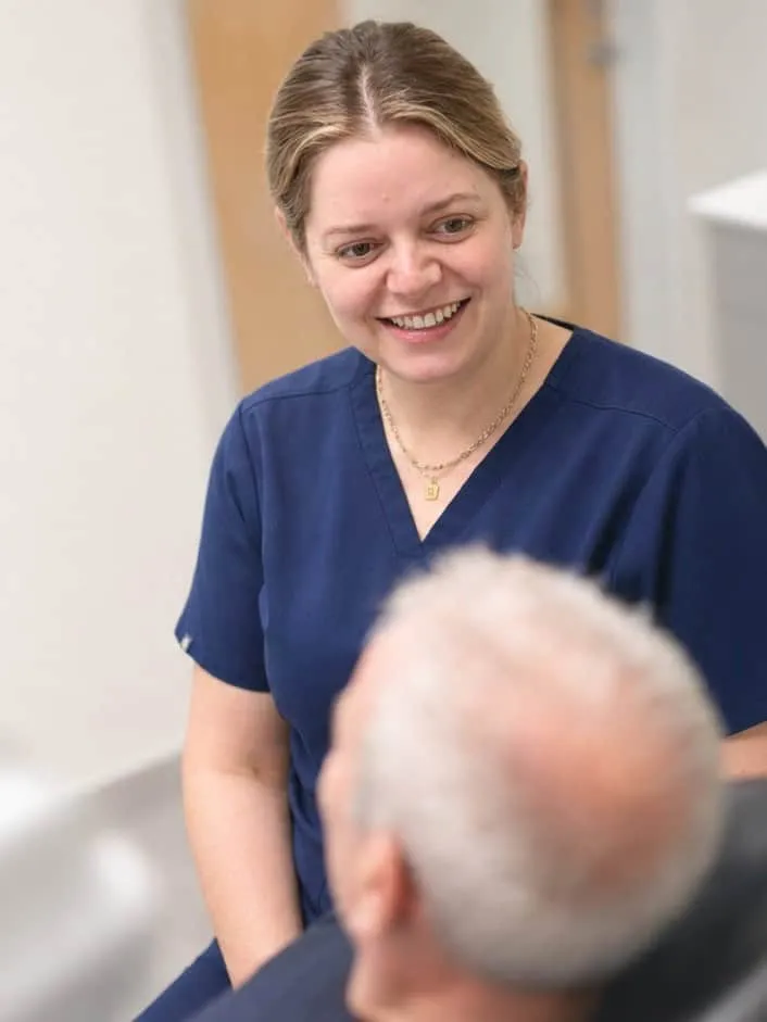 A dental nurse chatting with a patient in the treatment room