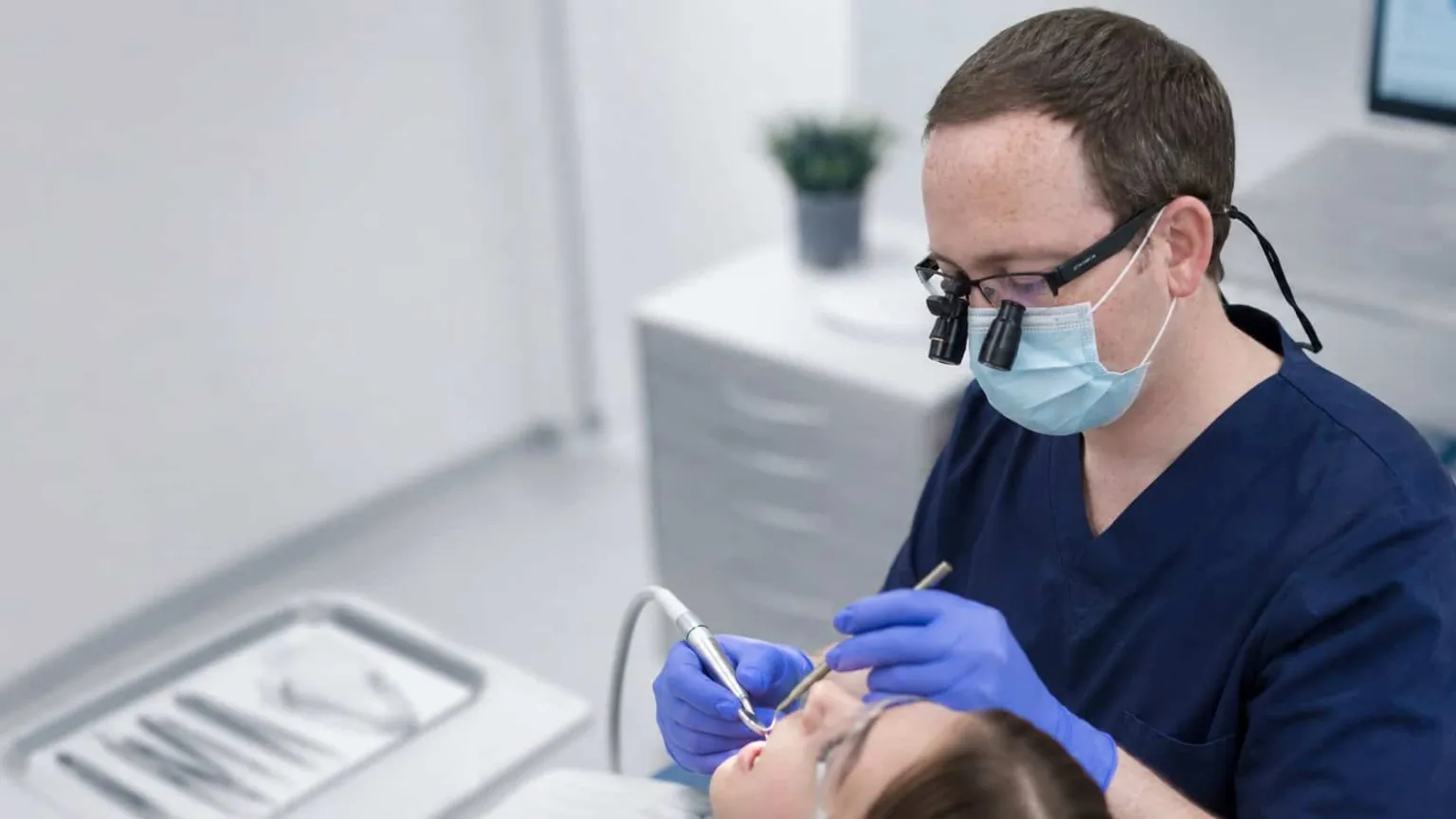 A dentist working in loupes